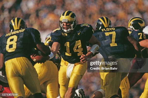 Brian Griese#14, Quarterback for the University of Michigan Wolverines hands the ball off to Running Back Chris Howard during the NCAA 84th Rose Bowl...