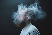 Concept. Smoke enveloped the head man. Portrait of a Bearded, stylish man with smoke. Secondhand smoke