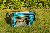 View of electric lawn aerator on green grass isolated. Garden machines concept.