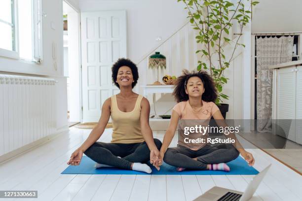 african-american woman and her daughter meditating at home - teen meditating stock pictures, royalty-free photos & images