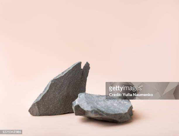 grey stone podium for cosmetics or products on brown beige background. modern layout presentation pedestal. - roccia foto e immagini stock