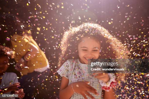 confetti falling on african-american little girl smiling outdoors - portrait looking down stock pictures, royalty-free photos & images