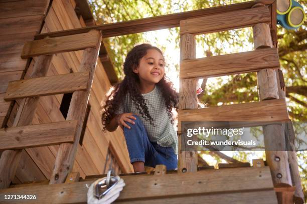 ung flicka leende leker i trädkoj på sommardagen - tree house bildbanksfoton och bilder
