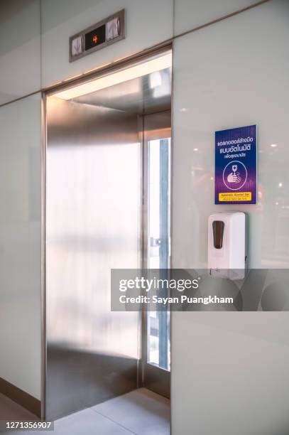 signboard displayed in front of the elevator, automatic alcohol gel, alcohol hand gel 70%, the alcohol gel hall below press apply, social distance rule. prevent covid-19. - social distancing elevator stock pictures, royalty-free photos & images