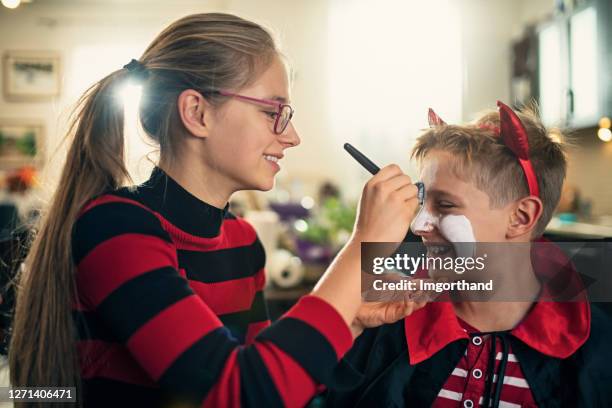 sister painting brother for halloween - halloween celebrations in italy stock pictures, royalty-free photos & images