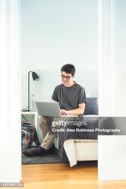 a latino teenager studying in his bedroom - alex boys stockfoto's en -beelden
