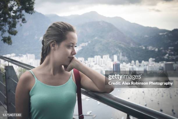 a solitary young woman set against the rio de janeiro skyline - poupando para o dia de amanhã imagens e fotografias de stock