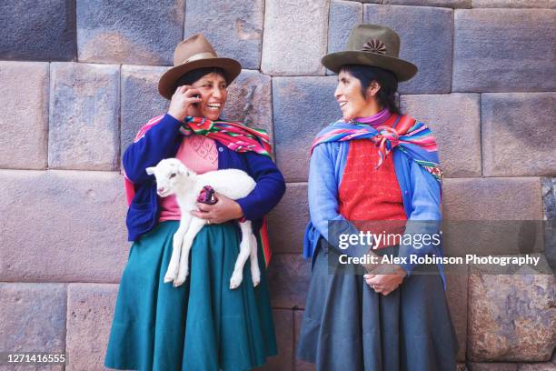 peruvian indigenous women in cusco, one using a cell phone - quechuas fotografías e imágenes de stock