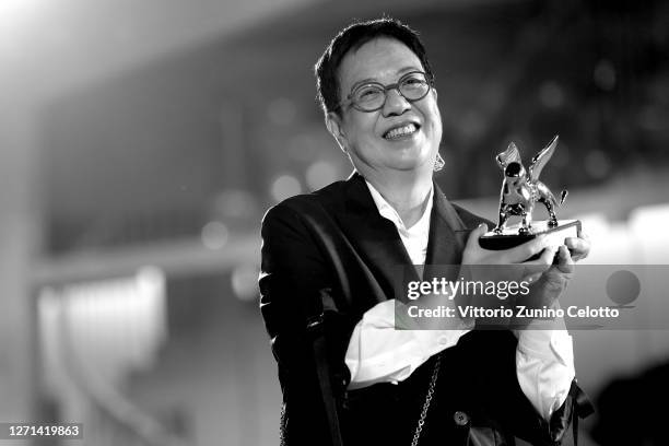 This image has been converted to black and white. Director Ann Hui poses on the red carpet with the Golden Lion Lifetime achievement award after the...