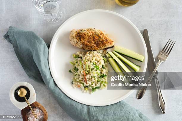 flat lay of chicken breast, cauliflower rice and cucumber - cauliflower rice stock pictures, royalty-free photos & images