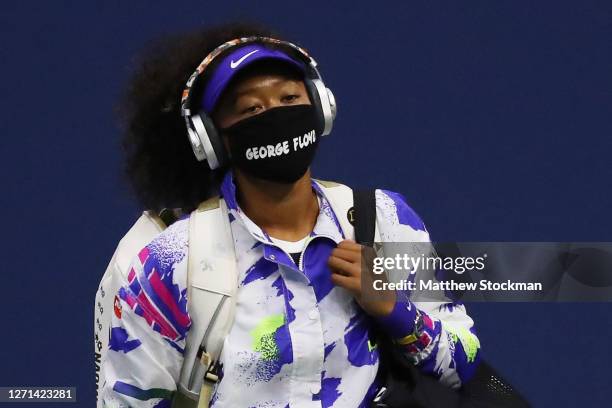 Naomi Osaka of Japan walks in wearing a mask with the name of George Floyd on it before her Women’s Singles quarter-finals match against Shelby...