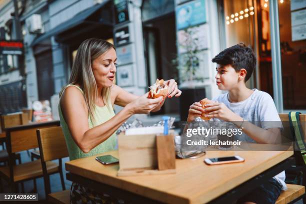 mama bringt ihr kind zum burger-ort - teenagers eating with mum stock-fotos und bilder