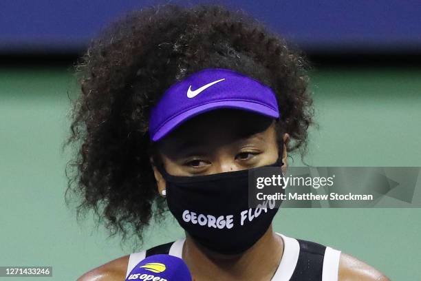 Naomi Osaka of Japan wears a mask with the name of George Floyd on it during an interview following her Women’s Singles quarter-finals match win...