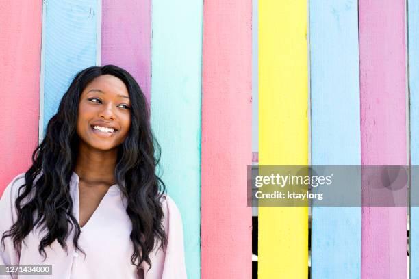 zelfverzekerde en verbluffende tiener buiten infront van neon-gekleurde muur - african american teen stockfoto's en -beelden