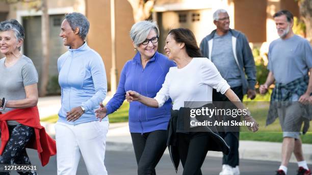 senior friends walking - active retirement community stock pictures, royalty-free photos & images