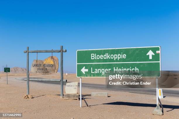 Signs along a road crossing the desert indicate the direction to the Bloedkoppie and to the Langer Heinrich uranium mine next to Swakopmund, Namibia,...