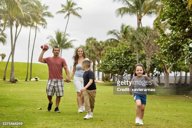 young hispanic family playing catch at miami public park - playing catch stock pictures, royalty-free photos & images