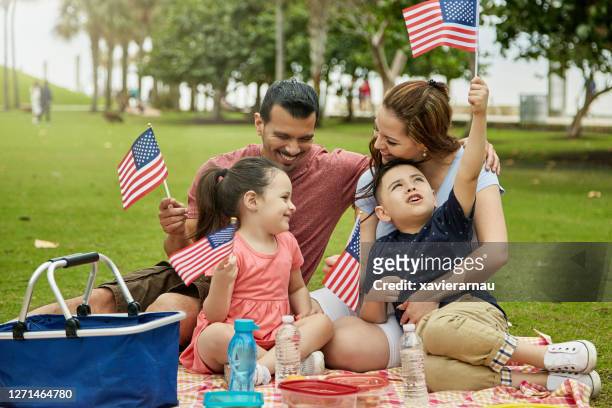 patriotic hispanic family picnicking at miami public park - happy independence day stock pictures, royalty-free photos & images