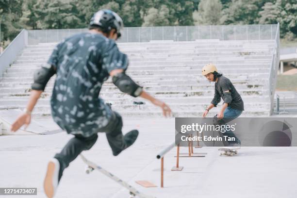 asian skateboarder in aktion konkurrieren einander fallen derutschengeländer - skate fail stock-fotos und bilder