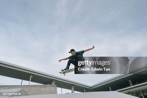 Asiatischer Skateboarder in Aktion in der Luft Asiatischer Skateboarder in Aktion in der Luft
