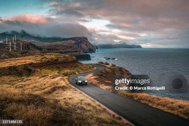 car driving on winding coastal road, madeira island, portugal - coastal road stock pictures, royalty-free photos & images