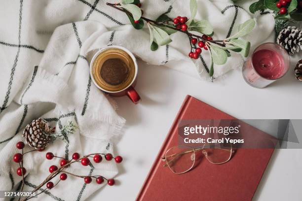 coffee cup with christmas ornaments and book, eyeglasses,  decoration on white background - christmas coffee stock-fotos und bilder