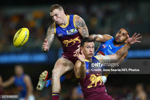 Mitch Robinson of the Lions, Hugh McCluggage of the Lions and Brandon Ellis of the Suns compete for the ball during the round 16 AFL match between...