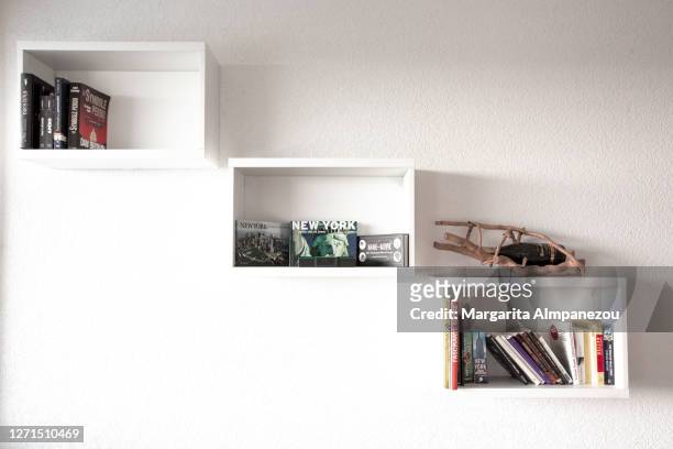 white bookshelves on the wall of modern bright apartment - shelf stock-fotos und bilder