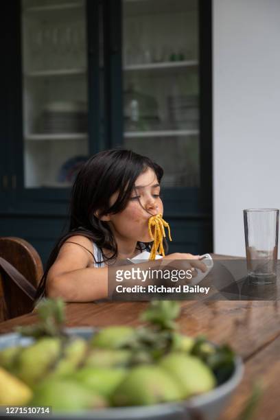 young girl eating spaghetti from a bowl, messily - the joys of eating spaghetti stock pictures, royalty-free photos & images