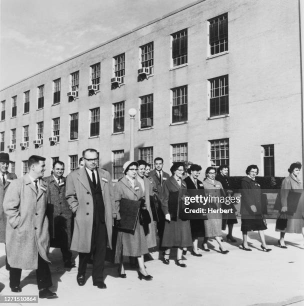 Census crew, a group of men and women, dressed in winter coats, holding document folders, as they carry out a census in an year, circa 1950.