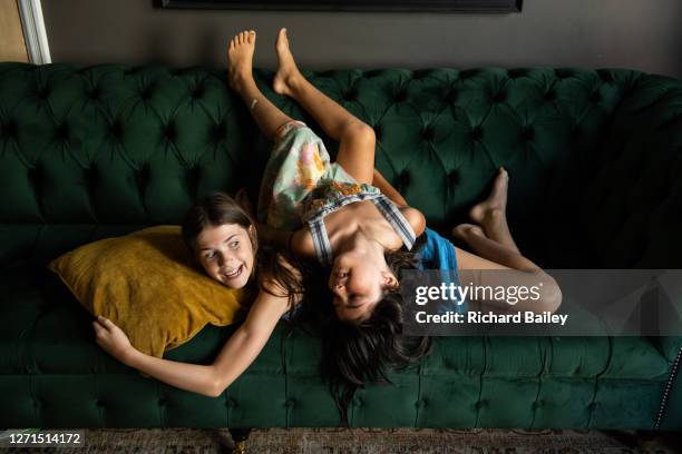 sisters playing on the sofa - lying on back girl on the sofa stock pictures, royalty-free photos & images
