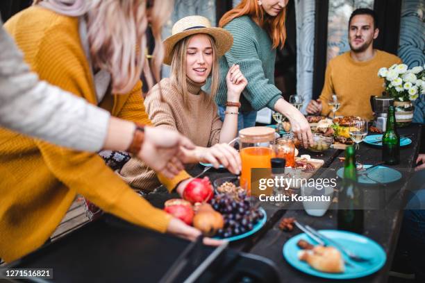 después de que terminaron con el brunch mujeres diligentes limpiando la mesa del comedor - brunch fotografías e imágenes de stock