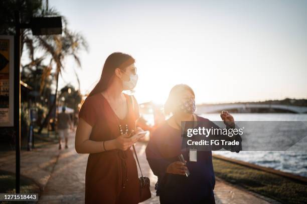 tourist guide and young traveller woman showing and visit sidewalk - wearing face mask - federal district stock pictures, royalty-free photos & images