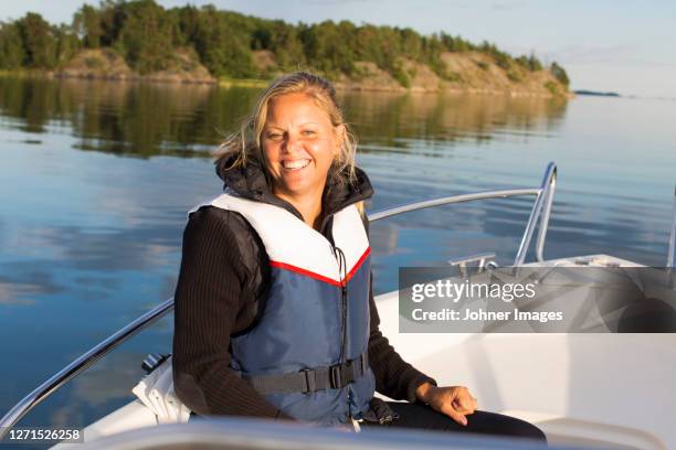 smiling woman on boat - motorboat stock pictures, royalty-free photos & images