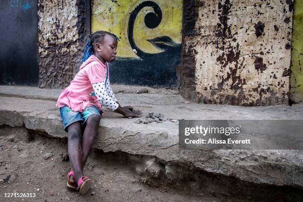 Girl plays a game with stones on July 9, 2020 in Nairobi, Kenya. Since school has been out, kids fill the streets of Mathare informal settlement....