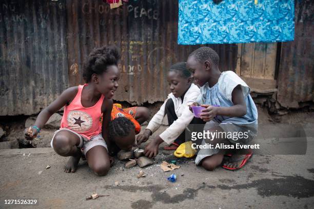 Group of young girls play a cooking game on the side of the street in Mathare informal settlement on July 9, 2020 in Nairobi, Kenya. School has been...