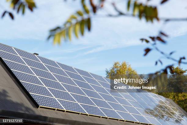 low angle view of solar panels on roof - zonnepanelen stockfoto's en -beelden