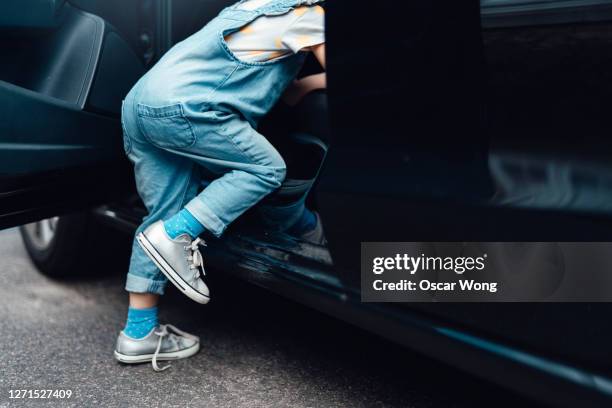 young girl getting into a car - first day of school car stock pictures, royalty-free photos & images