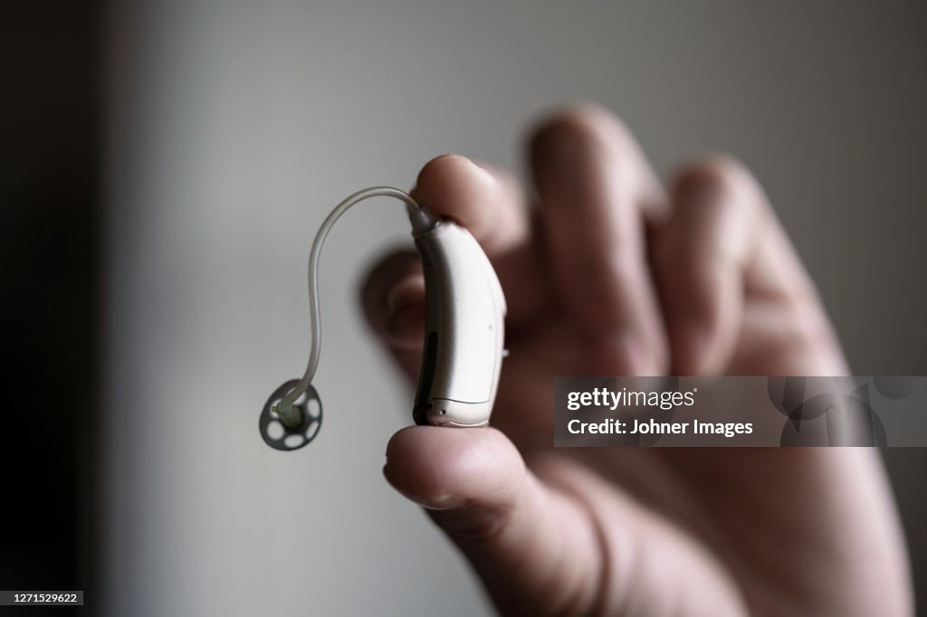 Hand holding hearing aid