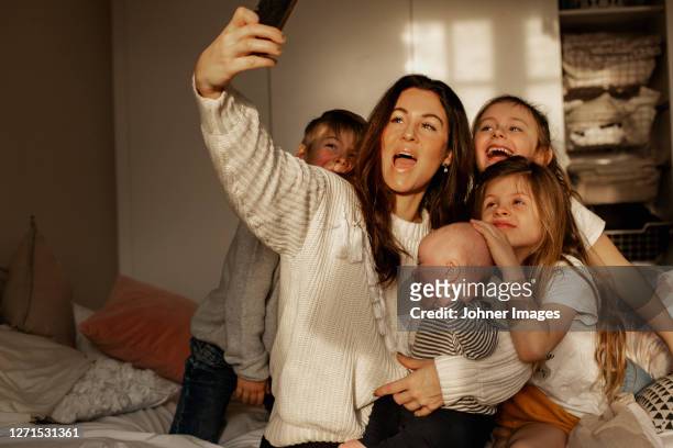 mother with children taking selfie - familie mit vier kindern stock-fotos und bilder