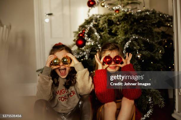 girls in front of christmas tree - christmas fun photos et images de collection