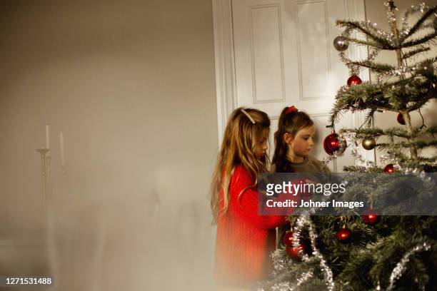 girls decorating christmas tree - johner christmas bildbanksfoton och bilder