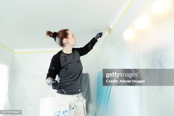 woman painting ceiling - bathroom ceiling stock pictures, royalty-free photos & images