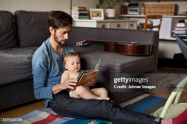 father reading book to baby - bedtime story book stock pictures, royalty-free photos & images