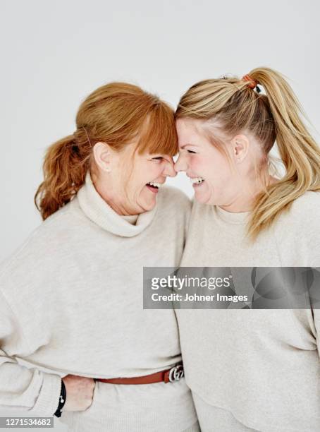 mother with adult daughter, studio shot - daughter stock-fotos und bilder