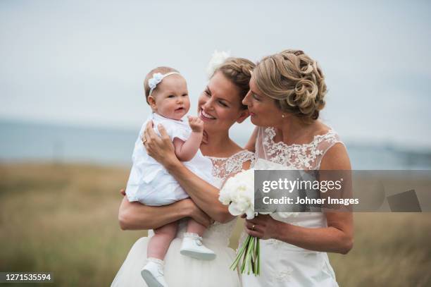 brides with baby girl - civil partnership stock pictures, royalty-free photos & images