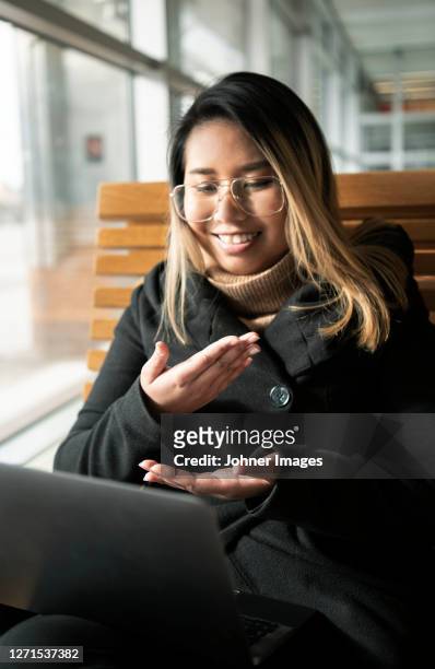 woman at train station using laptop - deaf signing stock pictures, royalty-free photos & images