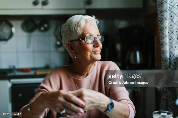 senior woman looking away - hoffnung stock-fotos und bilder