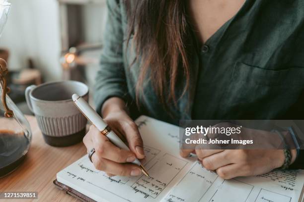 woman taking notes in her diary - planning agenda foto e immagini stock