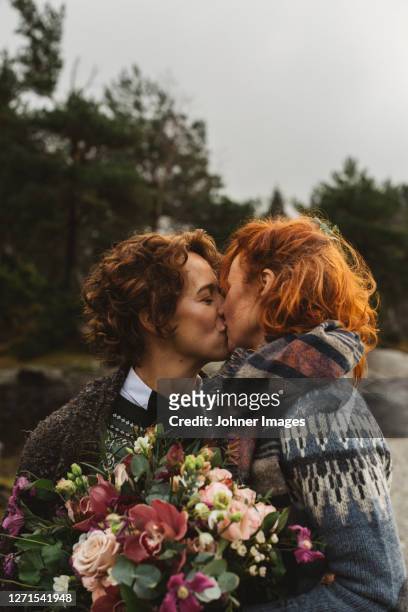 lesbian couple kissing outdoors - images of lesbians kissing stock pictures, royalty-free photos & images